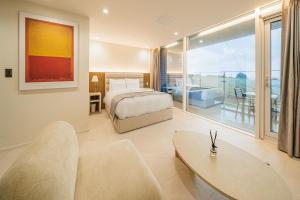 1 dormitorio con cama y ventana grande en Haeilri Pool&SPA Hotel en Seogwipo