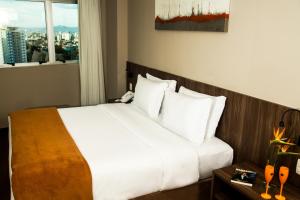 Tempat tidur dalam kamar di BH Raja Hotel