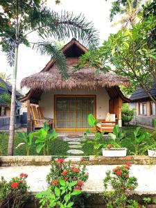 龍目島的住宿－Bintang Tiga Bungalows Gili Air，一间有稻草屋顶的小房子