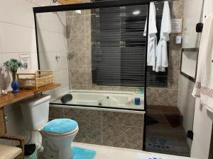 een badkamer met een toilet en een bad bij Casa de campo Domeni rustica e próximo a cidade de Juiz de Fora MG in Juiz de Fora