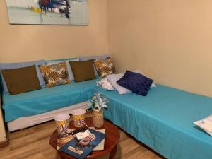 Sofá azul en la sala de estar con mesa en Casa de campo Domeni rustica e próximo a cidade de Juiz de Fora MG en Juiz de Fora