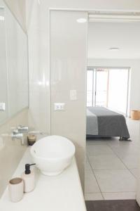 a white bathroom with a sink and a bed at Amplio Duplex Huanchaco - Vista al Mar y Ascensor in Trujillo +20 photos