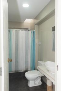 a bathroom with a toilet and a sink at Amplio Duplex Huanchaco - Vista al Mar y Ascensor in Trujillo