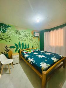 a bedroom with a bed with flowers on the wall at Byahero's Eskapo Hostel in Moalboal