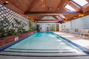 a pool in a building with a ceiling with skylights at Beaulieu Hotel in Lyndhurst