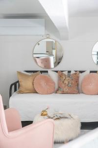 Upea loftsuite, järvinäkymä, wifi, sauna & spa في تامبير: غرفة بها سرير مع مرآة وكرسي وردي