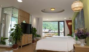 een slaapkamer met een wit bed en een televisie bij Tropical paradise Hotel & Coffee in Sa Pa