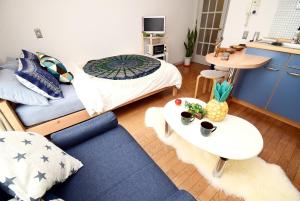 uma sala de estar com uma cama e um sofá azul em KITAZAWA CS HOUSE / Vacation STAY 68573 em Tóquio