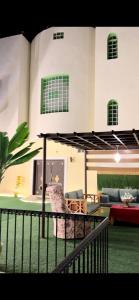 un soggiorno con tavolo e ombrellone di فيلا الوريك Villa Al Warik a Umm Lajj