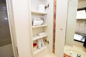 baño con estantes blancos y lavamanos en KITAZAWA CS HOUSE - Vacation STAY 45470v, en Tokio