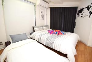 two beds sitting next to each other in a bedroom at KITAZAWA CS HOUSE / Vacation STAY 76588 in Tokyo