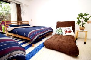 a bedroom with two beds and a chair in it at KITAZAWA CS HOUSE / Vacation STAY 78552 in Tokyo