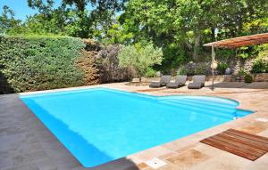 una piscina en un patio con sillas y sombrilla en La Villa Du Soleil, en Lacoste