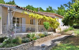 una casa con una valla y flores delante de ella en La Villa Du Soleil, en Lacoste