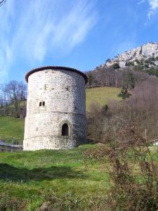 un edificio en un campo con una montaña en el fondo en Ca María Santa, en Proaza