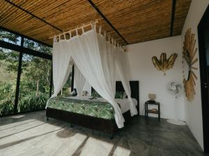 ein Schlafzimmer mit einem Himmelbett in der Unterkunft NABGUANA in Chinchiná