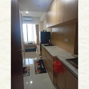 La cuisine est équipée d'un évier et d'un réfrigérateur. dans l'établissement Apartement Studio Pollux Habibi Batam A13712, à Batam Center