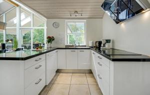a kitchen with white cabinets and black counter tops at Holiday Home Skælskør With Hot Tub Iv in Egerup