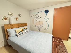 um quarto com uma cama com um mural na parede em Bee Inn Puerto Rico Charming Urban Apartment in San Juan em San Juan