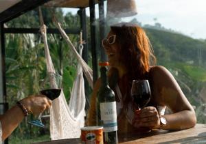a woman sitting at a table with a glass of wine at NABGUANA in Chinchiná