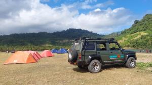 un jeep verde estacionado frente a las tiendas de campaña en Adventure Turtle Homestay Meru Betiri, en Sarungan