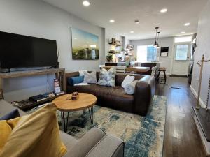 uma sala de estar com um sofá e uma televisão em Capitol Hill Adjacent Home Steps to Park and River em Washington