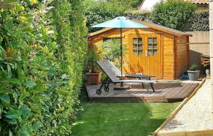 a bench and an umbrella on a deck next to a wooden shed at Villa Nathis in Maillane