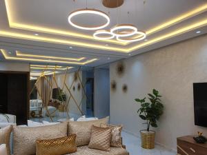 a living room with a couch and a chandelier at Le Sélect Appartement in Nador