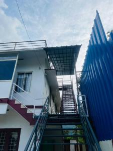 eine Treppe, die zu einem Gebäude mit Blau führt in der Unterkunft Kadampil Bliss in Maraiyūr