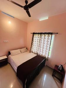 - une chambre avec un lit et un ventilateur de plafond dans l'établissement Kadampil Bliss, à Maraiyūr
