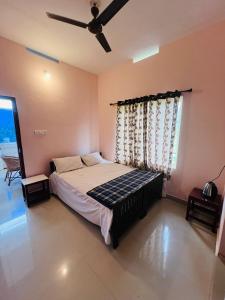 sypialnia z łóżkiem i wentylatorem sufitowym w obiekcie Kadampil Bliss w mieście Maraiyūr