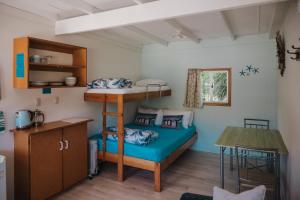 een kleine kamer met een stapelbed en een tafel bij Golden Bay Holiday Park in Onekaka