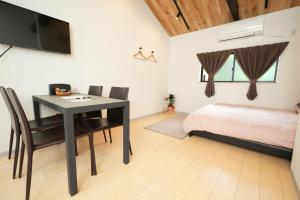 a bedroom with a table and a bed and a television at 三十三Kin in Kyoto