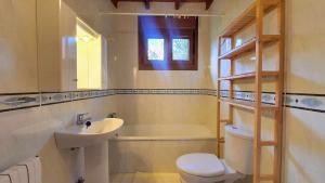 a bathroom with a sink and a toilet and a bath tub at Complejo Rural El Mirador de Ovio in Cuevas +82 photos