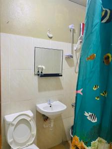 a bathroom with a toilet and a sink at Byahero's Eskapo Hostel in Moalboal