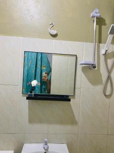 a person taking a picture of a mirror in a bathroom at Byahero's Eskapo Hostel in Moalboal +21 photos