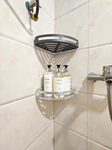 a shelf in a bathroom with three bottles of soap at SKYINN Aparment 橙堡整套复式公寓 in Shenzhen