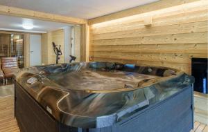 eine Stahlwanne in einem Raum mit einer Holzwand in der Unterkunft Nice Home In Gérardmer With Sauna in Gérardmer