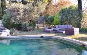 a swimming pool in a yard with a couch and a chair at Mas Anastasia in Les Baux-de-Provence