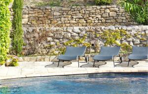 three chairs sitting next to a swimming pool at Mas Anastasia in Les Baux-de-Provence