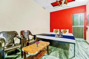 a room with a table and chairs and a red wall at SPOT ON Hotel Aman Palace in Bhopal +32 photos