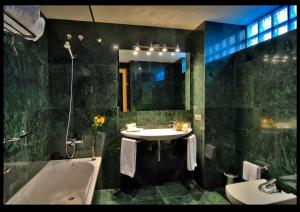 W łazience znajduje się umywalka, wanna i umywalka. w obiekcie Hotel Conde de Cárdenas w Kordobie