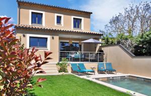 una casa con piscina e sedie blu di La Maison Adriel a Saumane-de-Vaucluse