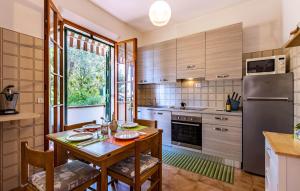 Una cocina con una mesa de madera y un refrigerador. en Gorgeous Apartment In Castiglioncello, en Castiglioncello
