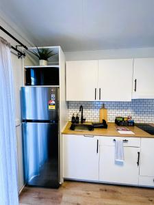 a kitchen with a blue refrigerator and white cabinets at Stylish tiny home in Melton west in Melton