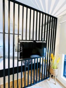 a black fence with a television in a living room at Stylish tiny home in Melton west in Melton