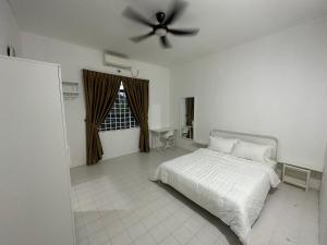 a bedroom with a white bed and a ceiling fan at Mawar 23 Chendering with Private Pool in Kuala Terengganu