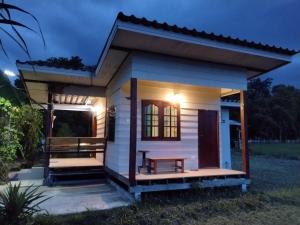 een klein wit tiny house met een veranda in de nacht bij ID Garden Home in Ban Cham Kha