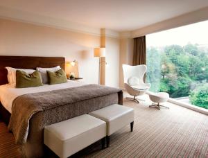 um quarto de hotel com uma cama e uma janela grande em The River Lee Hotel a member of The Doyle Collection em Cork