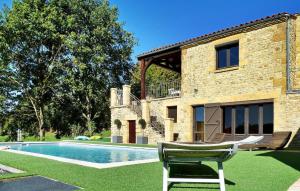 a chair in front of a house with a swimming pool at La Poujade in Sarlat-la-Canéda